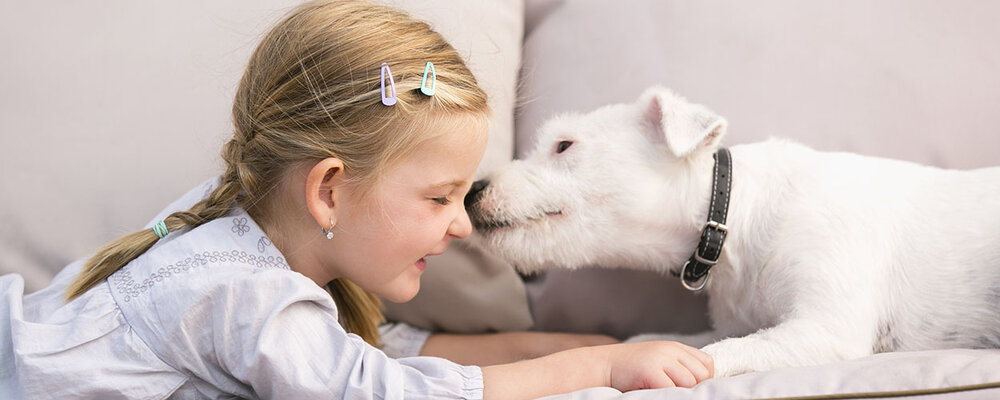 Girl Lying on Kid-Friendly Fabric With Dog